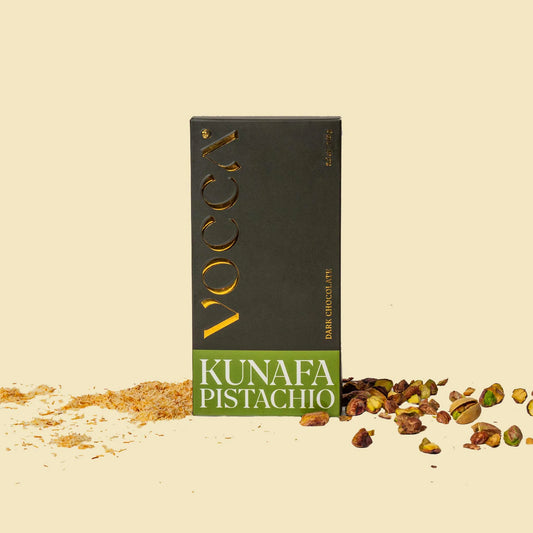 Vocca Kunafa Pistachio chocolate bar packaging on a beige background with pistachios.